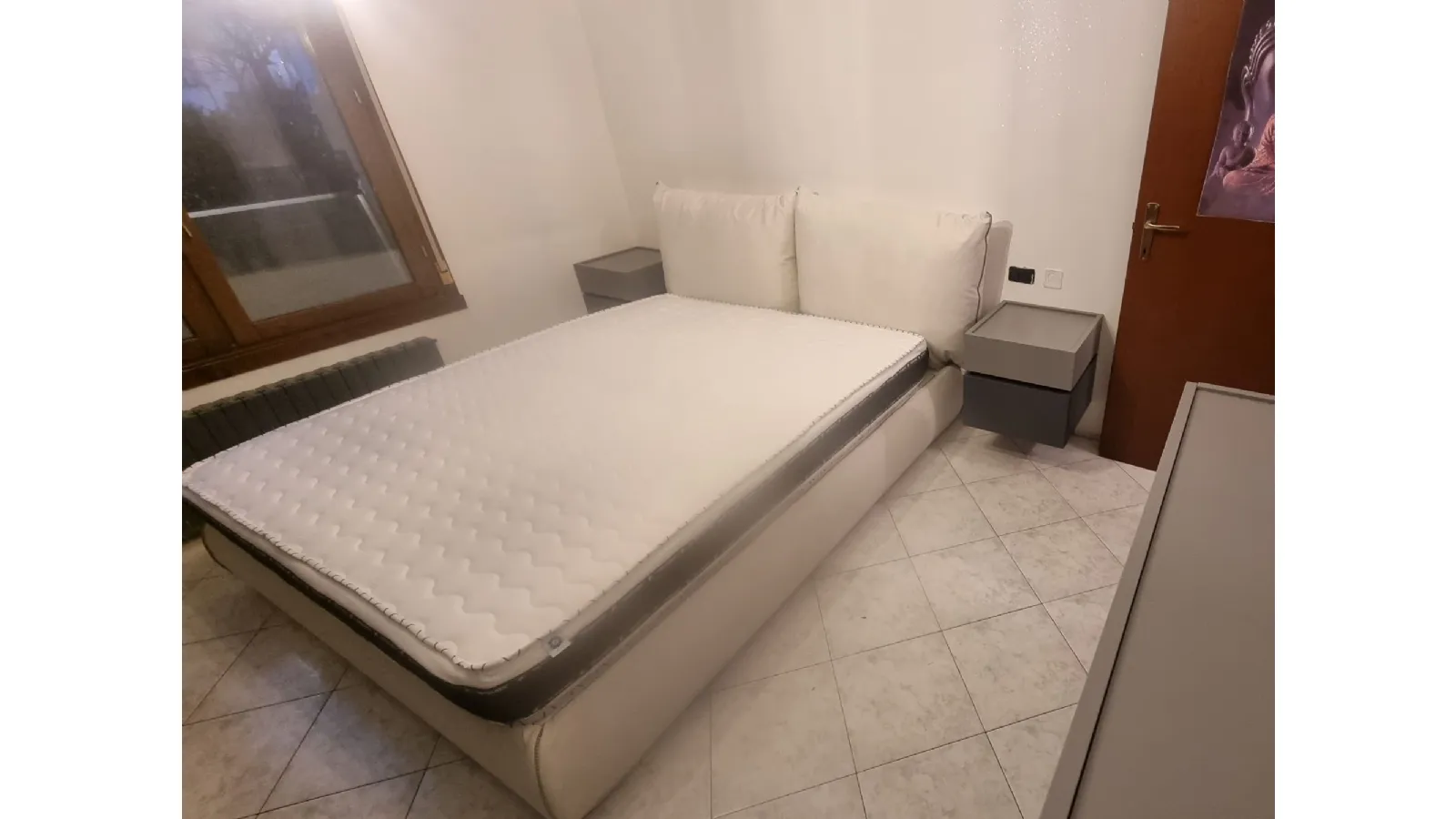 Camera con gruppo letto sospeso e cabina armadio con porte in vetro 